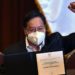 Bolivian President-elect Luis Arce raises his clenched fist as he poses with his credentials after getting them from the president of the Bolivian Supreme Electoral Tribunal (TSE) Salvador Romero (out of frame) at the Central Bank's auditorium in La Paz on October 28, 2020. (Photo by AIZAR RALDES / AFP)