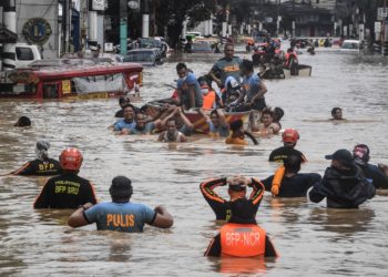 Rescuers pull a rubber boat carrying residents through a flooded street after Typhoon Vamco hit in Marikina City, suburban Manila on November 12, 2020. (Photo by Ted ALJIBE / AFP)