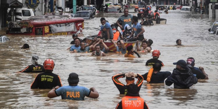 Rescuers pull a rubber boat carrying residents through a flooded street after Typhoon Vamco hit in Marikina City, suburban Manila on November 12, 2020. (Photo by Ted ALJIBE / AFP)