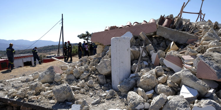 Firefighters stand next to a demolished Greek Orthodox church of Profitis Ilias after a strong earthquake in Arkalochori village on the southern island of Crete, Greece, Monday, Sept. 27, 2021. A strong earthquake with a preliminary magnitude of 5.8 has struck the southern Greek island of Crete, and Greek authorities say one person has been killed and several more have been injured. (AP Photo/Harry Nikos)