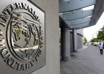 Pedestrians walk past the International Monetary Fund headquarters' complex in Washington Sunday, May 2, 2010. A senior International Monetary Fund official says the IMF's executive board is meeting in Washington to consider how much aid to grant Athens under a massive rescue loan package. (AP Photo/Cliff Owen)