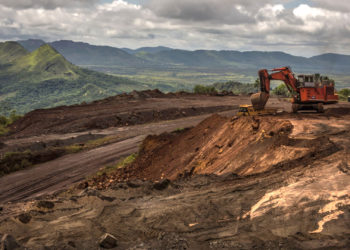 An excavator moves earth to a dump truck at a mining site of Venezuelan iron ore producer CVG Ferrominera Orinoco, on Bolivar Hill outside of Ciudad Piar, Venezuela, on Thursday, July 9, 2015. Photographer: Meridith Kohut/Bloomberg