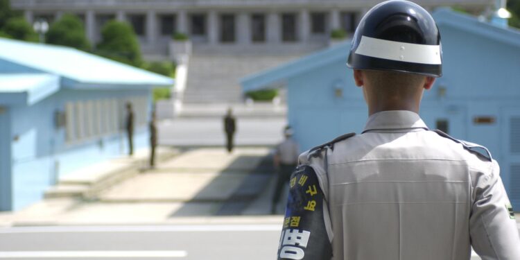 South Korean Soldier stands guard on the DMZ, North Korea is in the background