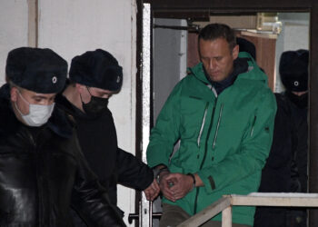 TOPSHOT - Opposition leader Alexei Navalny is escorted out of a police station on January 18, 2021, in Khimki, outside Moscow, following the court ruling that ordered him jailed for 30 days. - Kremlin critic Alexei Navalny on Monday urged Russians to stage mass anti-government protests during a court hearing after his arrest on arrival in Moscow from Germany. (Photo by Alexander NEMENOV / AFP) (Photo by ALEXANDER NEMENOV/AFP via Getty Images)