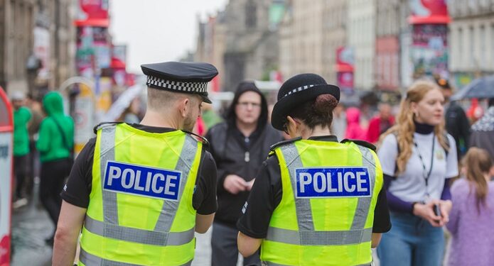 Edinburgh city police keep an eye on crowds at the Royal Mile during Edinburgh Fringe Festival.