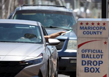 PHOENIX, ARIZONA - AUGUST 02: A voter places a ballot in a drop box outside of the Maricopa County Elections Department on August 02, 2022 in Phoenix, Arizona. Arizonans are heading to the polls to vote in the state's midterm primary election. (Photo by Justin Sullivan/Getty Images)